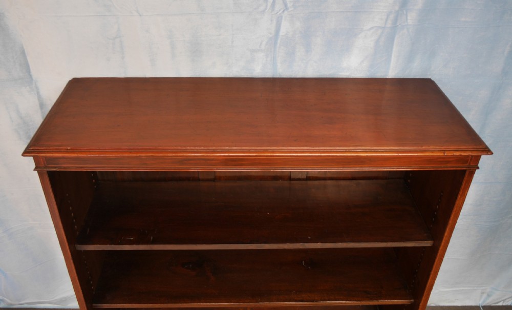 An Edwardian open mahogany bookcase featuring two adjustable shelves, a panelled back, and a solid plinth base. View VIII