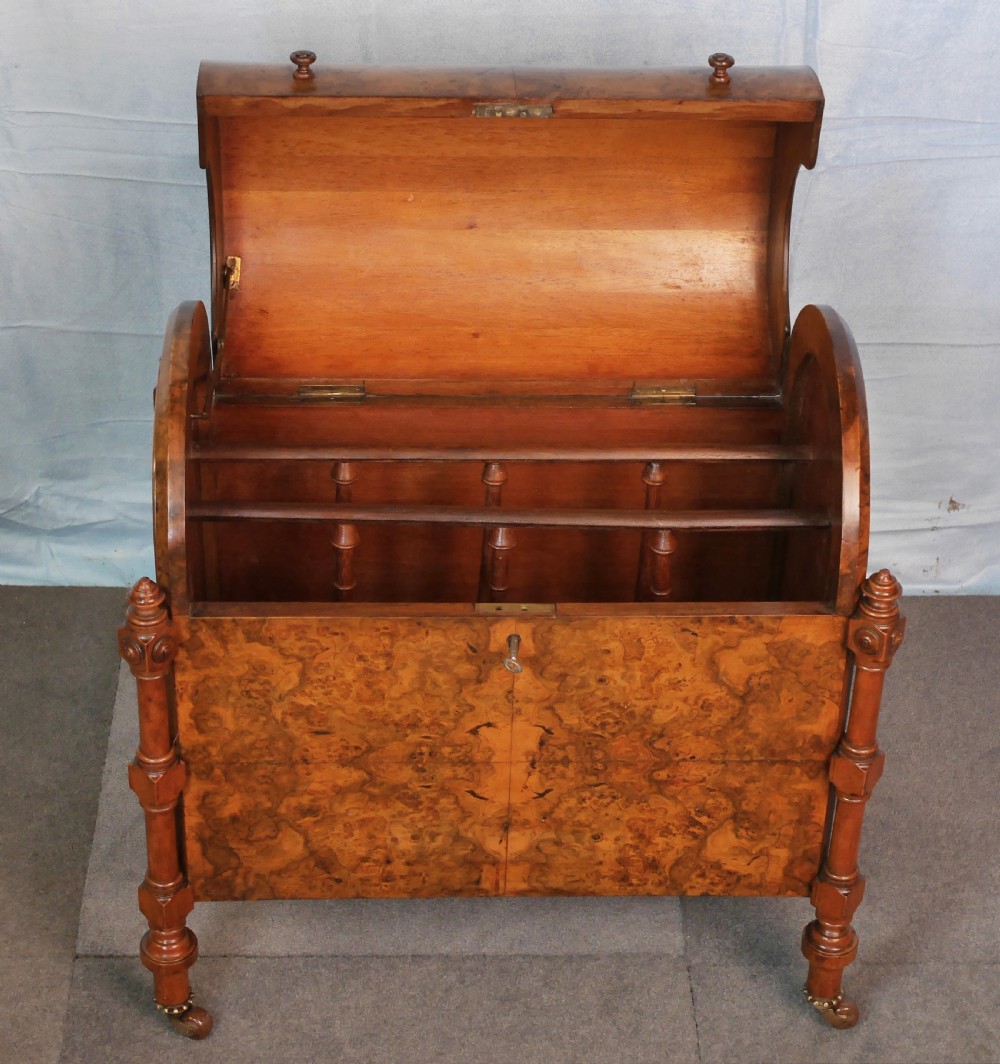 A Victorian burr walnut music canterbury featuring a rounded barrel lid, book-matched veneer panels, turned corner columns, and brass castors. View III