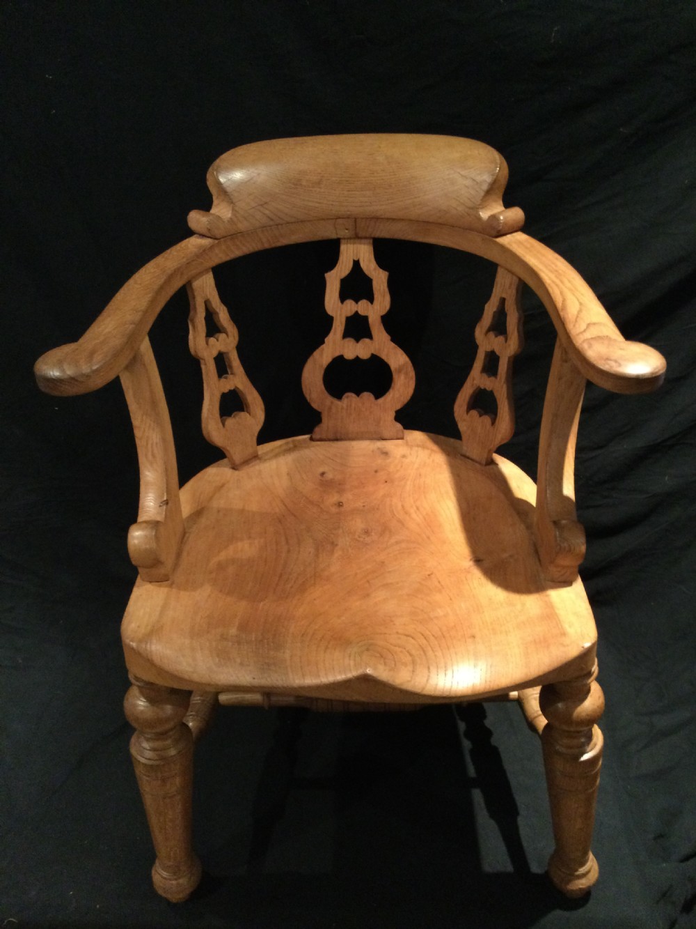 Set of four Victorian light brown wooden captains armchairs with curved backrests, pierced splats, shaped saddle seats, and turned legs. View VII