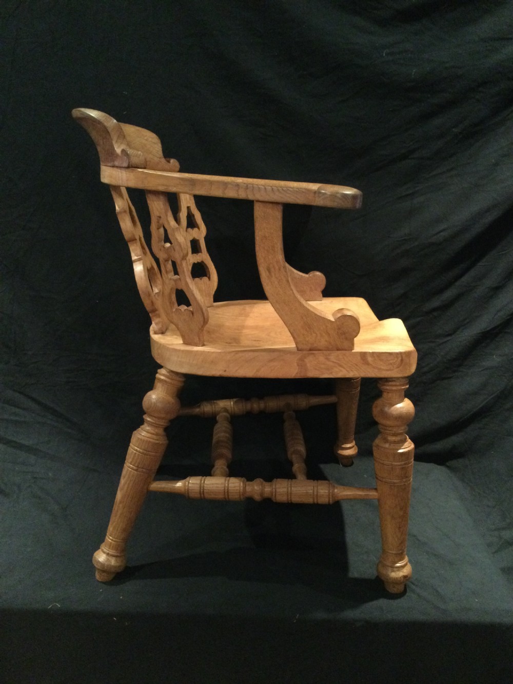 Set of four Victorian light brown wooden captains armchairs with curved backrests, pierced splats, shaped saddle seats, and turned legs. View IX