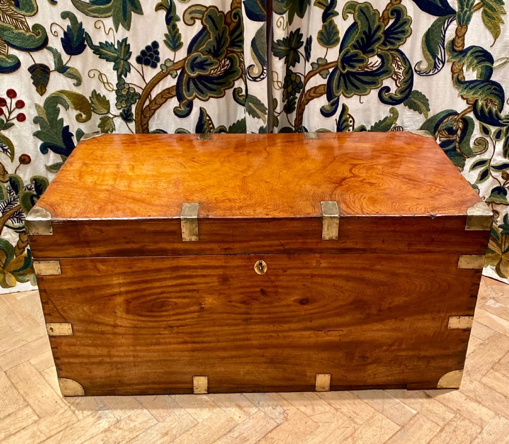 A rectangular warm brown camphor wood trunk featuring brass corner bindings, side carrying handles, and a central keyhole. View II
