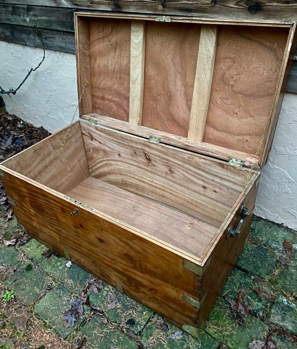 A rectangular warm brown camphor wood trunk featuring brass corner bindings, side carrying handles, and a central keyhole. View XIII