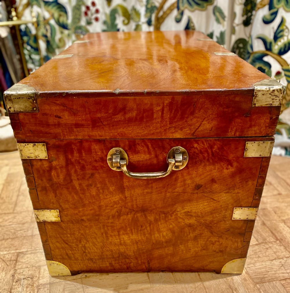 A rectangular warm brown camphor wood trunk featuring brass corner bindings, side carrying handles, and a central keyhole. View XVI