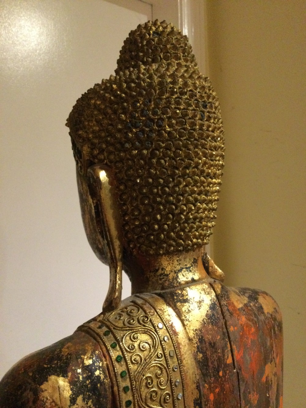 A standing carved wooden Buddha figure featuring aged gold leaf gilding, dark lacquer finish, and ornate draped robes. View IX