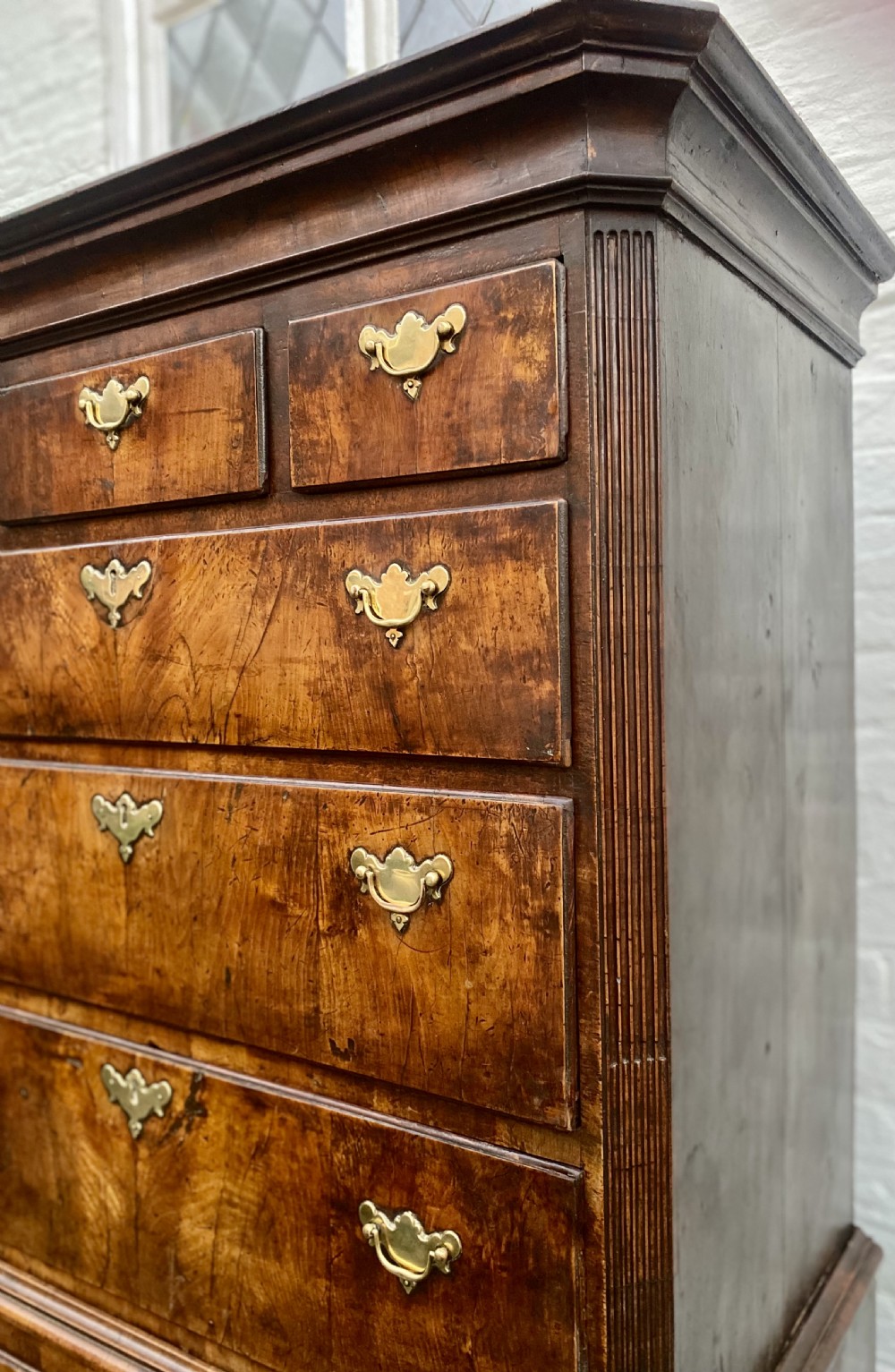 A tall Georgian burr walnut chest-on-chest featuring stacked drawers with brass drop handles and bracket feet. View VIII