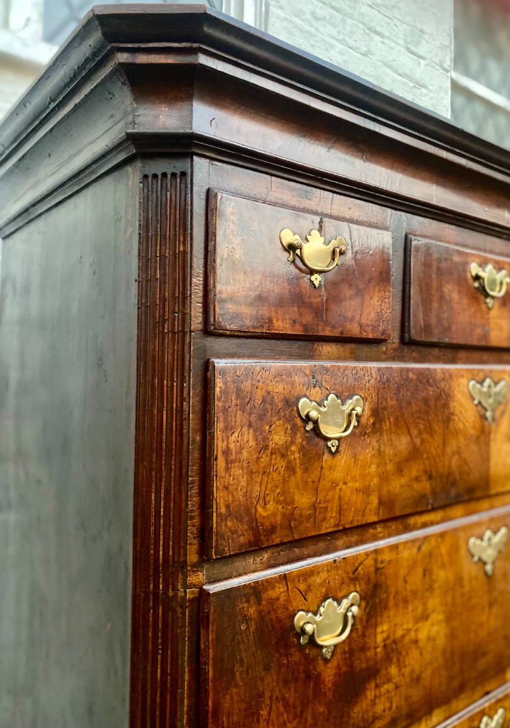 A tall Georgian burr walnut chest-on-chest featuring stacked drawers with brass drop handles and bracket feet. View IX