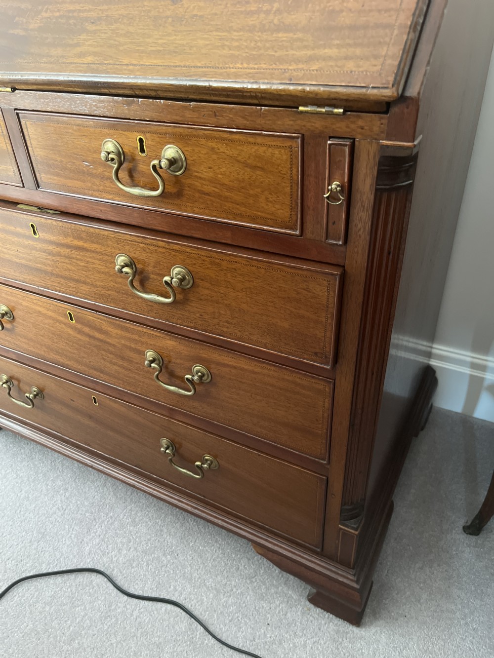 A Georgian mahogany writing bureau featuring a sloped hinged lid above four graduating drawers with brass swan-neck handles. View II