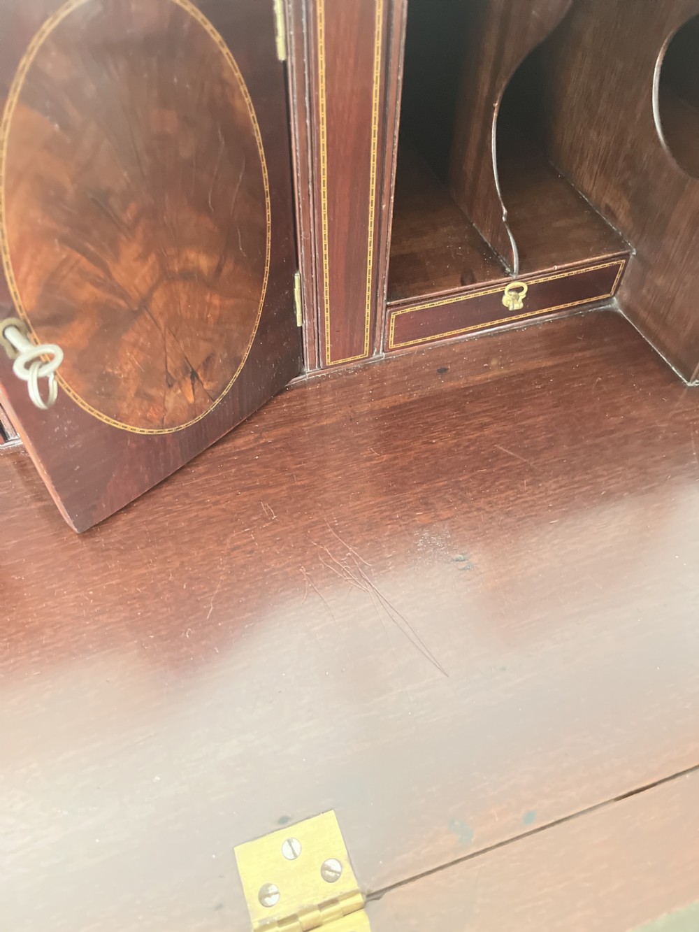 A Georgian mahogany writing bureau featuring a sloped hinged lid above four graduating drawers with brass swan-neck handles. View IV