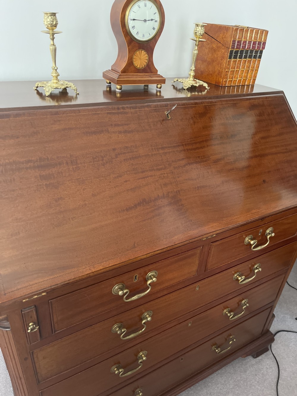 A Georgian mahogany writing bureau featuring a sloped hinged lid above four graduating drawers with brass swan-neck handles. View VIII