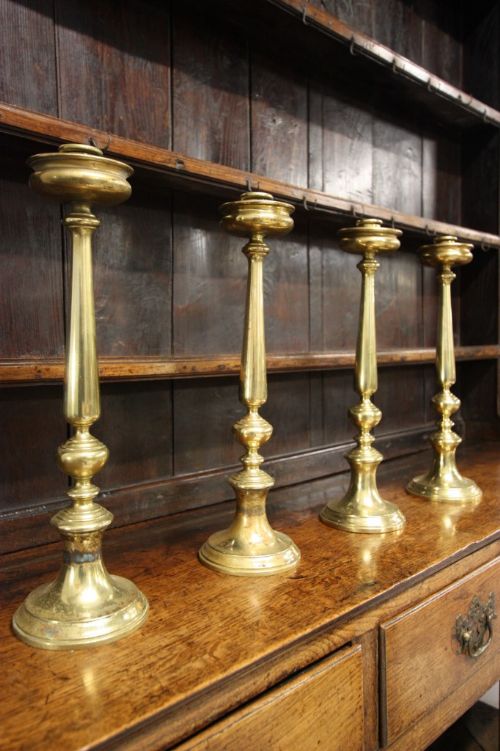 Set of Four Tall Antique Brass Candlesticks.