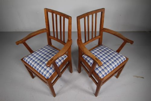 A pair of 1930s solid oak open armchairs featuring vertical slat backs, flattened armrests, and blue and white checked upholstered seats. View VI