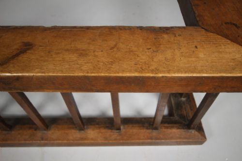 A 19th-century solid oak club fender featuring vertical spindle supports, a flat top wooden seat, and open return ends. View II