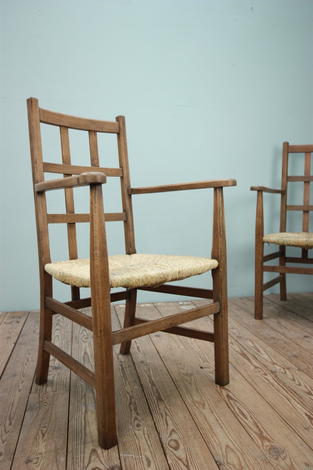 A Rare Pair of Heals Antique Oak Armchairs.