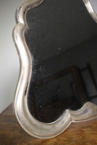 A 19th-century silver-gilt mirror featuring a contoured frame and an age-foxed glass plate. View II