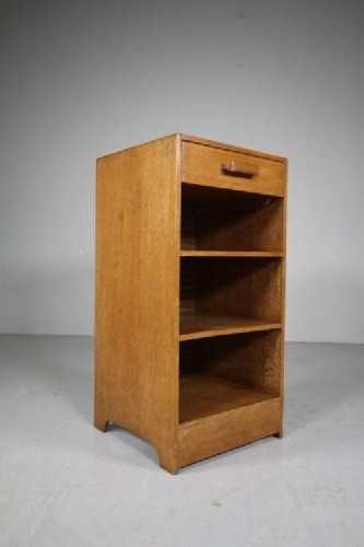 A 1930s light oak bedside cabinet with a single top drawer featuring a horizontal wooden bar handle situated above three open rectangular shelves. View IV