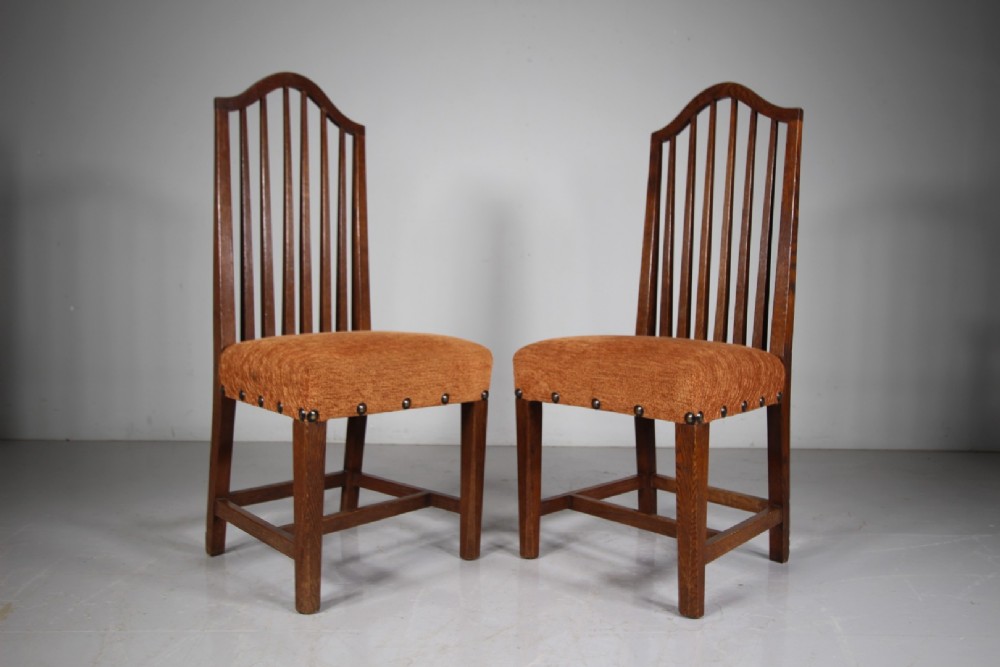 Set of six solid oak Arts and Crafts dining chairs featuring tall spindled backs and terracotta fabric upholstered seats. View IX