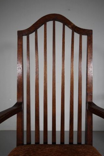 Set of six solid oak Arts and Crafts dining chairs featuring tall spindled backs and terracotta fabric upholstered seats. View VI