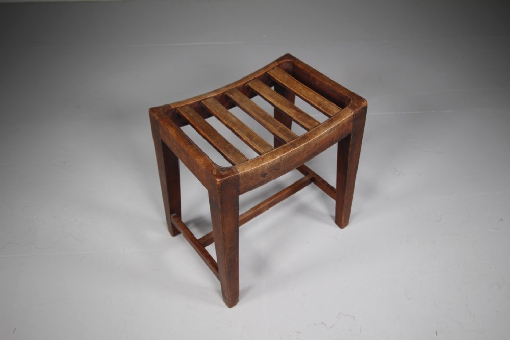 An English Georgian mahogany stool featuring a concave slatted seat, square tapered legs, and a low H-stretcher frame. View IV