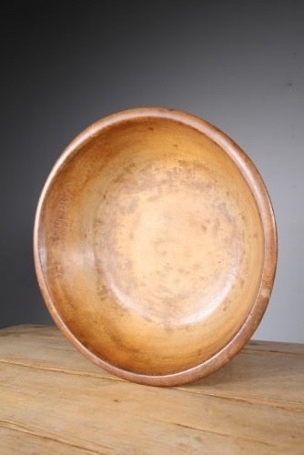 A large 19th-century turned sycamore wooden dairy bowl showing natural grain patina and turned rim detail.