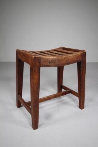 An English Georgian mahogany stool featuring a concave slatted seat, square tapered legs, and a low H-stretcher frame.