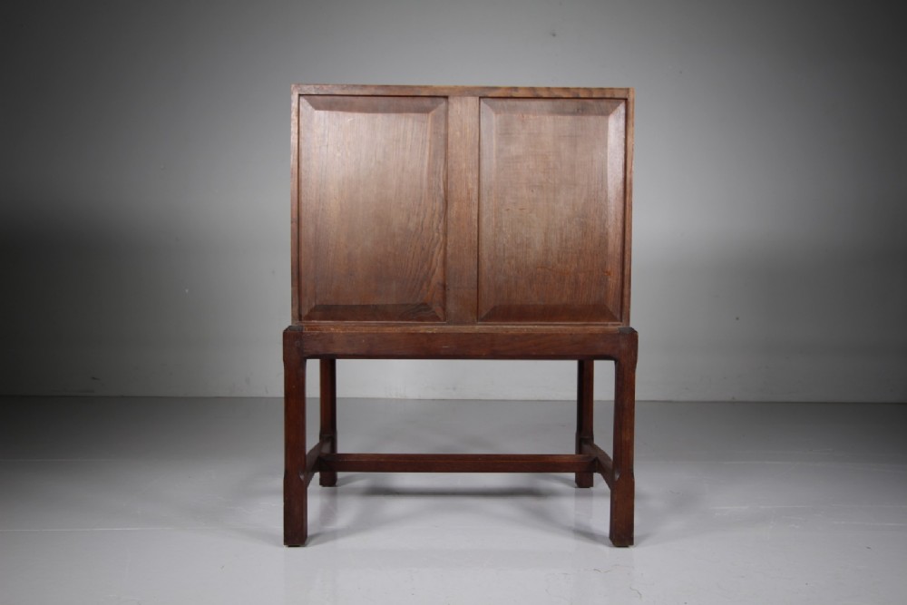 A 1930s oak writing bureau featuring a sloping fall-front lid over two drawers, supported by square legs with an H-stretcher. View VIII