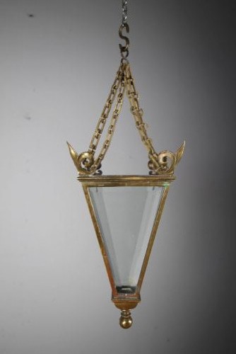 An early 19th-century inverted triangular brass hanging lantern with clear glass panels, corner finials, and suspension chains. View III