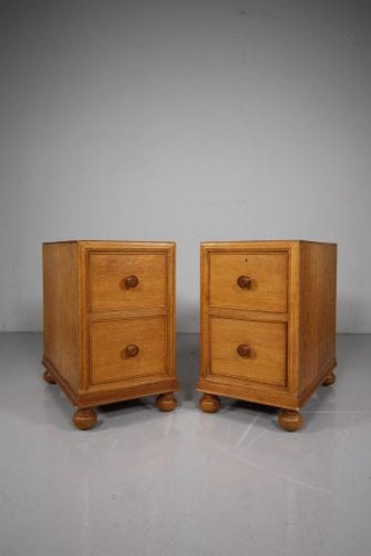 A pair of antique golden oak bedside chests, each containing two drawers with turned wooden knob handles and resting on bun feet. View II