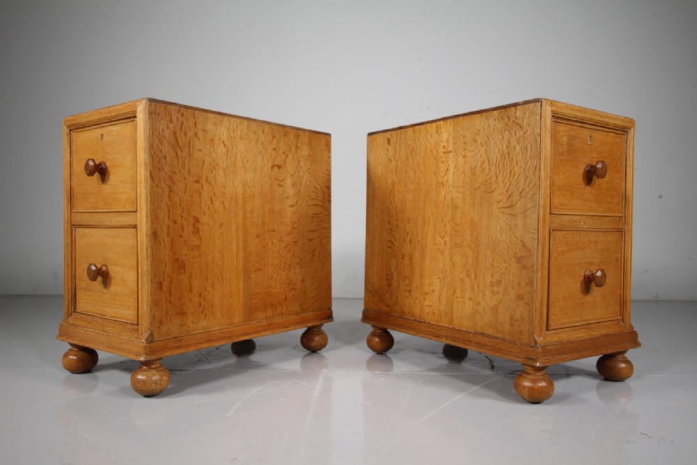 A pair of antique golden oak bedside chests, each containing two drawers with turned wooden knob handles and resting on bun feet. View III