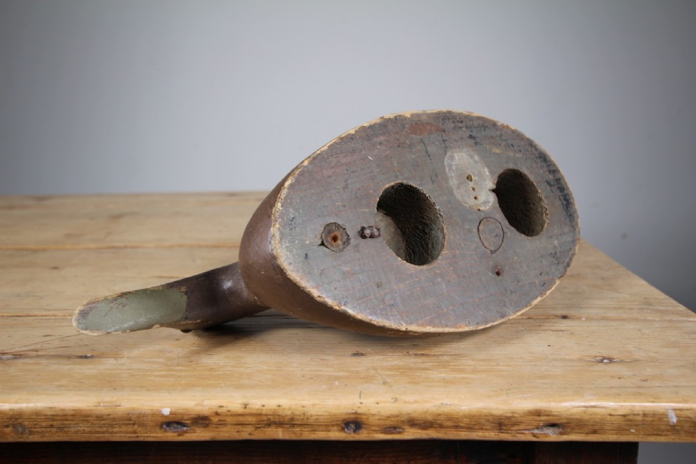 A 19th-century carved wooden decoy duck with a dark brown painted finish shown in profile. View IV