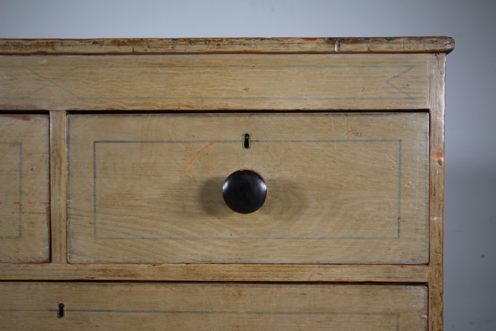 A Regency original painted pine chest of drawers featuring two short over two long drawers, turned legs, dark knobs, and hand-painted border lines. View III