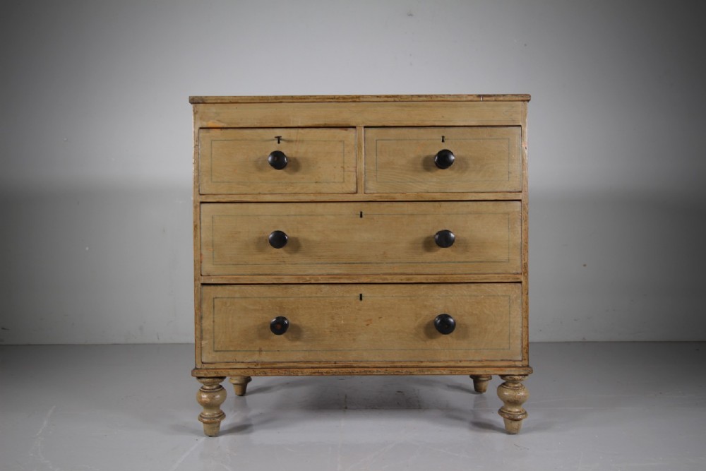 A Regency original painted pine chest of drawers featuring two short over two long drawers, turned legs, dark knobs, and hand-painted border lines. View V