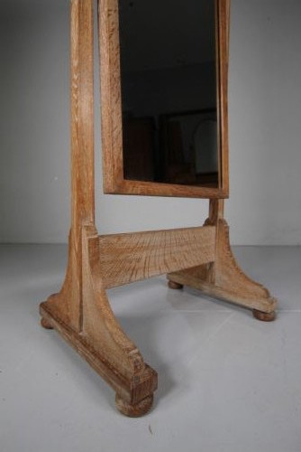An antique Edwardian light oak cheval mirror featuring a rectangular tilting mirror frame set within two vertical posts resting on trestle feet. View IV