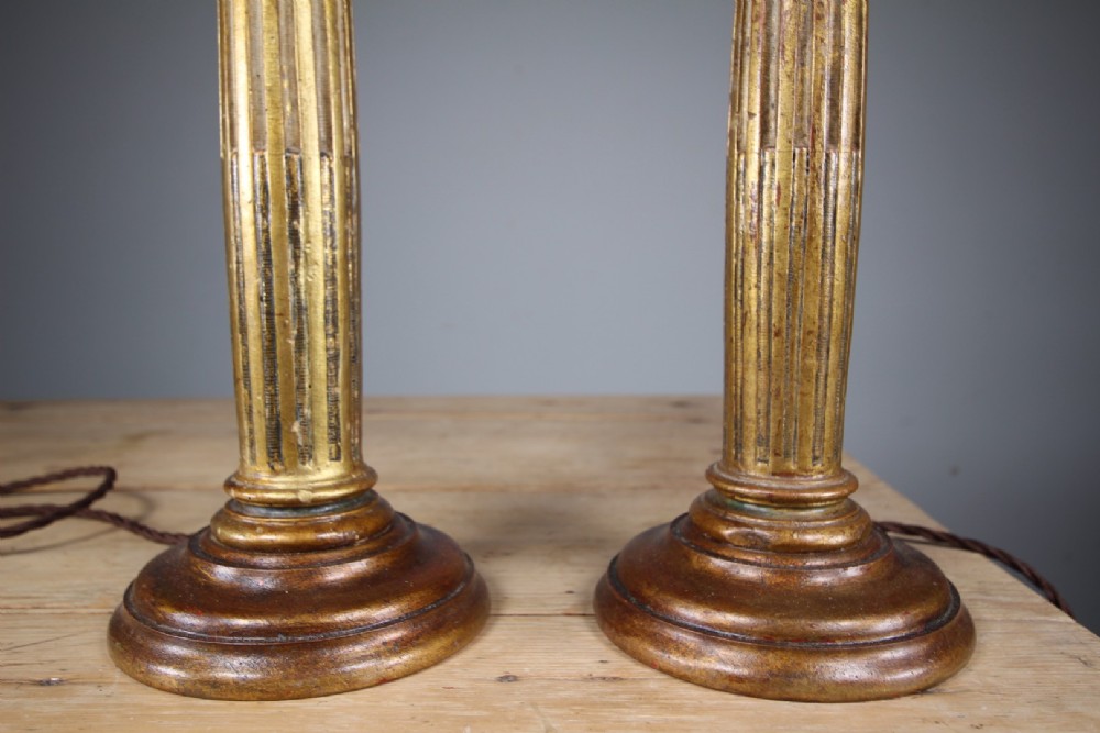 A pair of tall nineteenth-century gilt table lamps fashioned as fluted Ionic columns set on circular moulded bases. View V