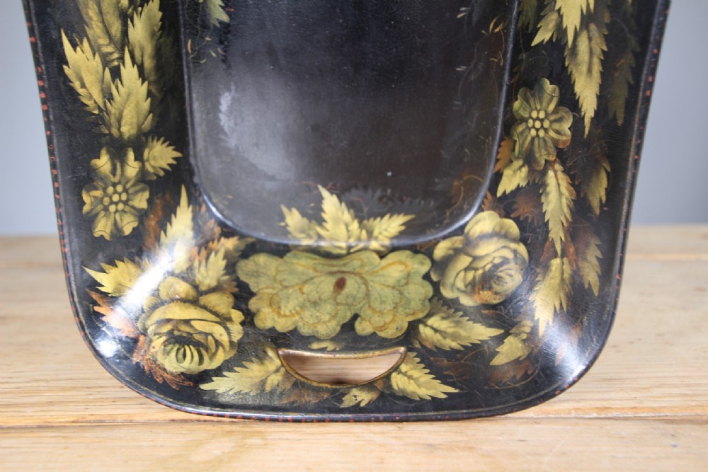 An antique black lacquered papier-mache tray featuring hand-painted gold floral borders and integrated side handles. View II