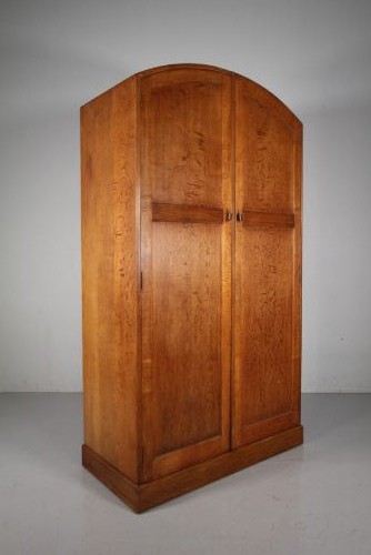 A 1930s oak double wardrobe featuring an arched top cornice, panelled twin doors, and a natural warm oak finish. View II