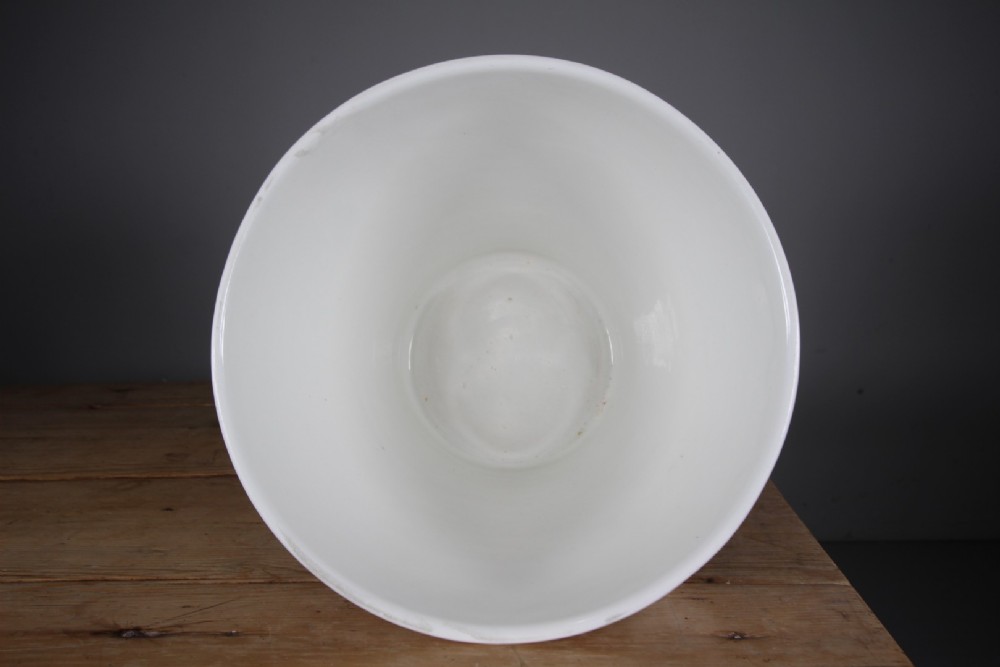 A white glazed ironstone dairy pail featuring integrated side handles, horizontal ribbed detailing, and a black transferware illustration of cows above the text PURE MILK. View V