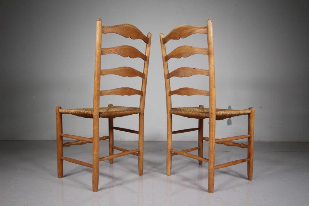 A pair of 1920s Arts and Crafts oak side chairs with ladderback frames and woven rush seats. View II