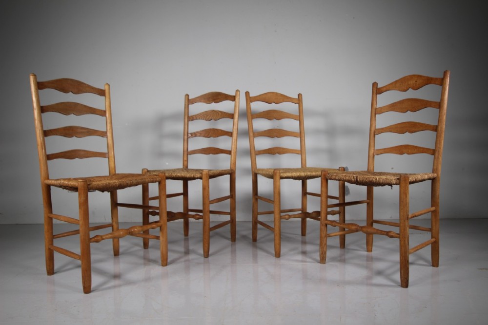 A set of four vintage Arts and Crafts ladderback dining chairs featuring natural woven rush seats and turned timber stretchers. View III