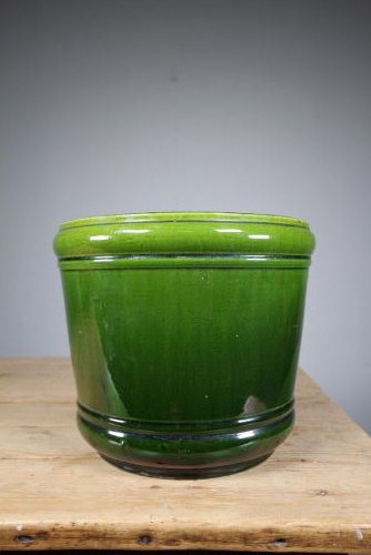 A large cylindrical Victorian Burmantofts ceramic plant pot featuring a rich green glaze and subtle horizontal moulded banding around the rim and base.