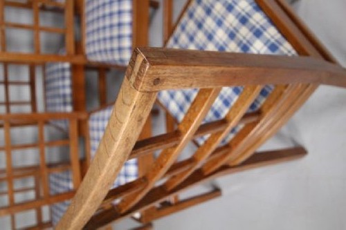 Set of six warm brown wooden dining chairs featuring open grid backrests and plaid upholstered drop-in seats. View VIII