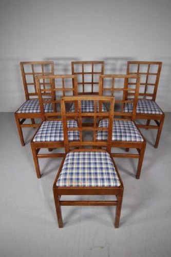 Set of six warm brown wooden dining chairs featuring open grid backrests and plaid upholstered drop-in seats. View VII