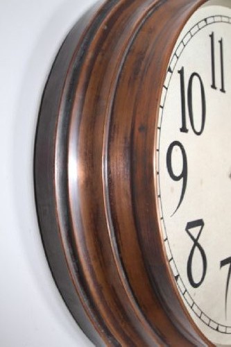 A circular antique Edwardian wall clock featuring a copper bezel, off-white dial with black Arabic numerals, and stylized spade hands. View II