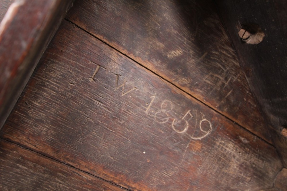 A nineteenth-century dark oak three-legged cricket table featuring a circular top bound with a studded brass rim and supported by a triangular stretcher. View IX