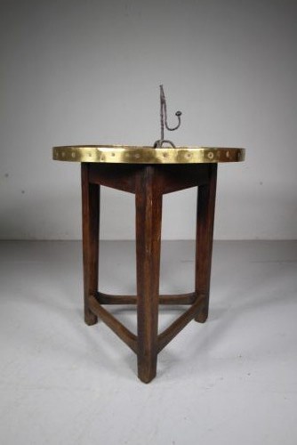 A nineteenth-century dark oak three-legged cricket table featuring a circular top bound with a studded brass rim and supported by a triangular stretcher. View V
