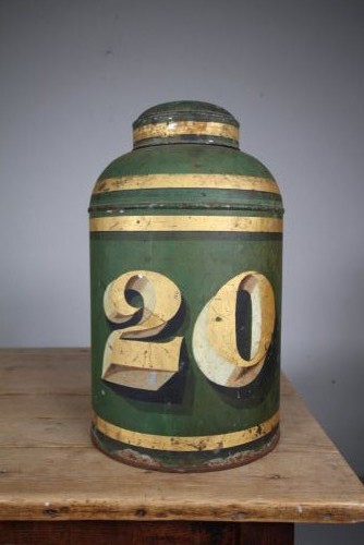 A large cylindrical nineteenth-century green painted toleware tea tin featuring decorative gold bands around the shoulder and lid.