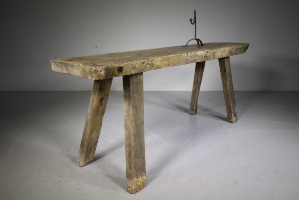 A low, thick-topped Georgian oak pig bench with four rustic splayed legs displaying a natural weathered finish. View IV