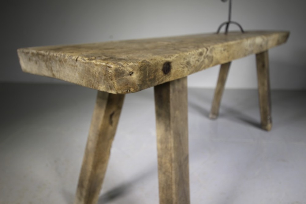 A low, thick-topped Georgian oak pig bench with four rustic splayed legs displaying a natural weathered finish. View V