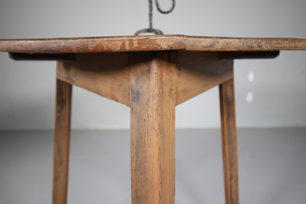An 18th-century painted pine cricket table featuring a circular wooden top supported by three legs and triangular lower stretchers. View IV