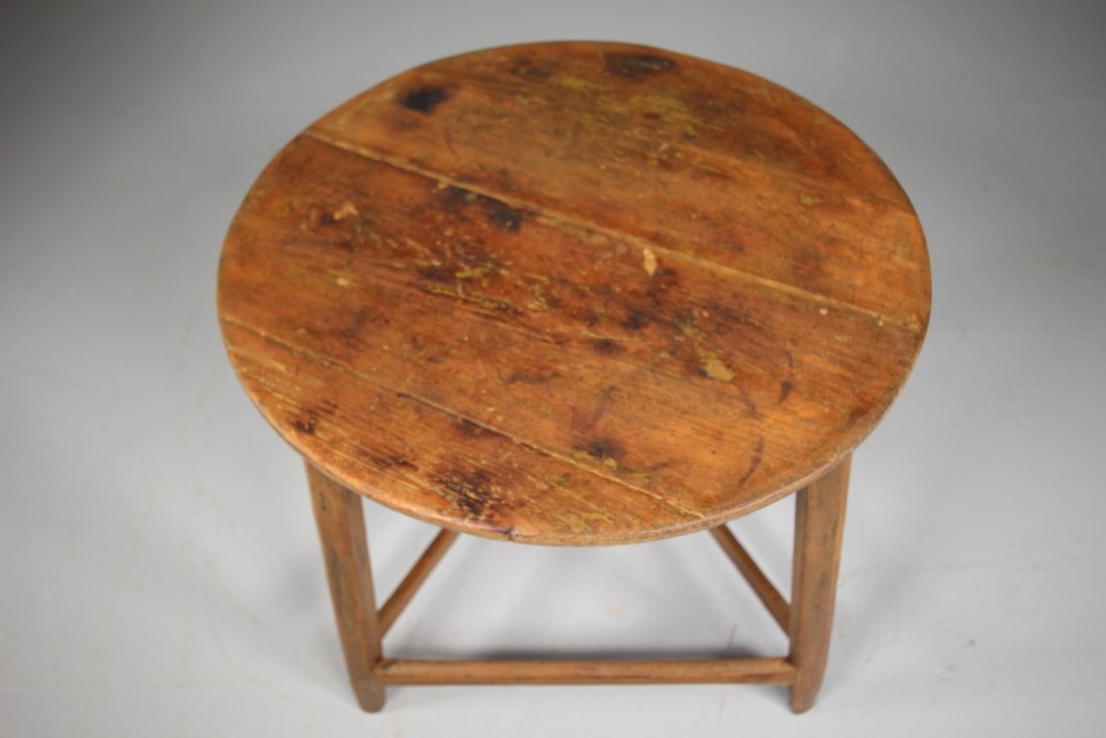 An 18th-century painted pine cricket table featuring a circular wooden top supported by three legs and triangular lower stretchers. View VIII