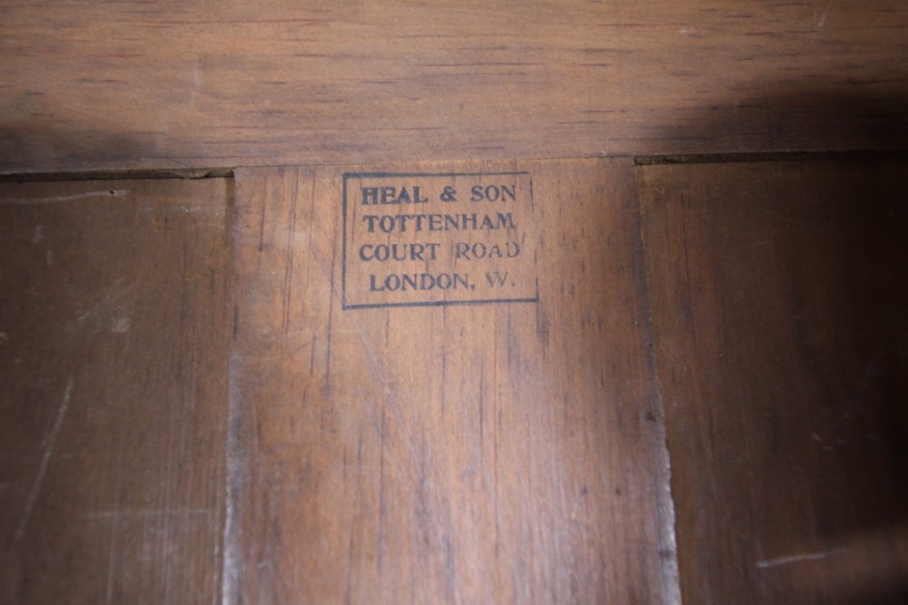 An Arts and Crafts solid oak cupboard featuring hand-forged wrought iron strap hinges, a single panelled door, and a lower drawer. View VI